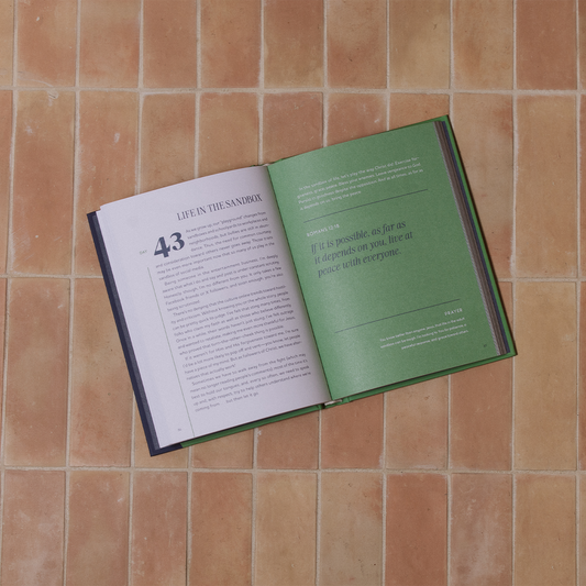 Open book on a tiled floor with visible text