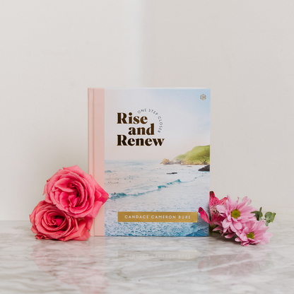Book titled 'Rise and Renew' by Candace Cameron Bure with pink flowers on a light surface